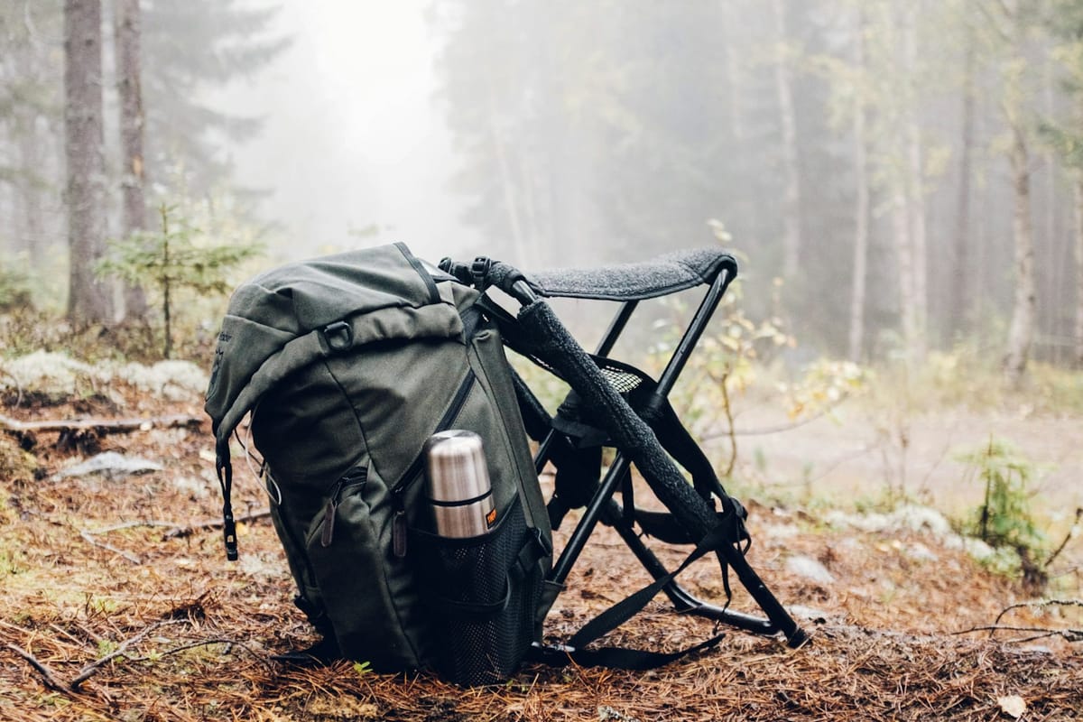 Backpack and folding chair in a forest