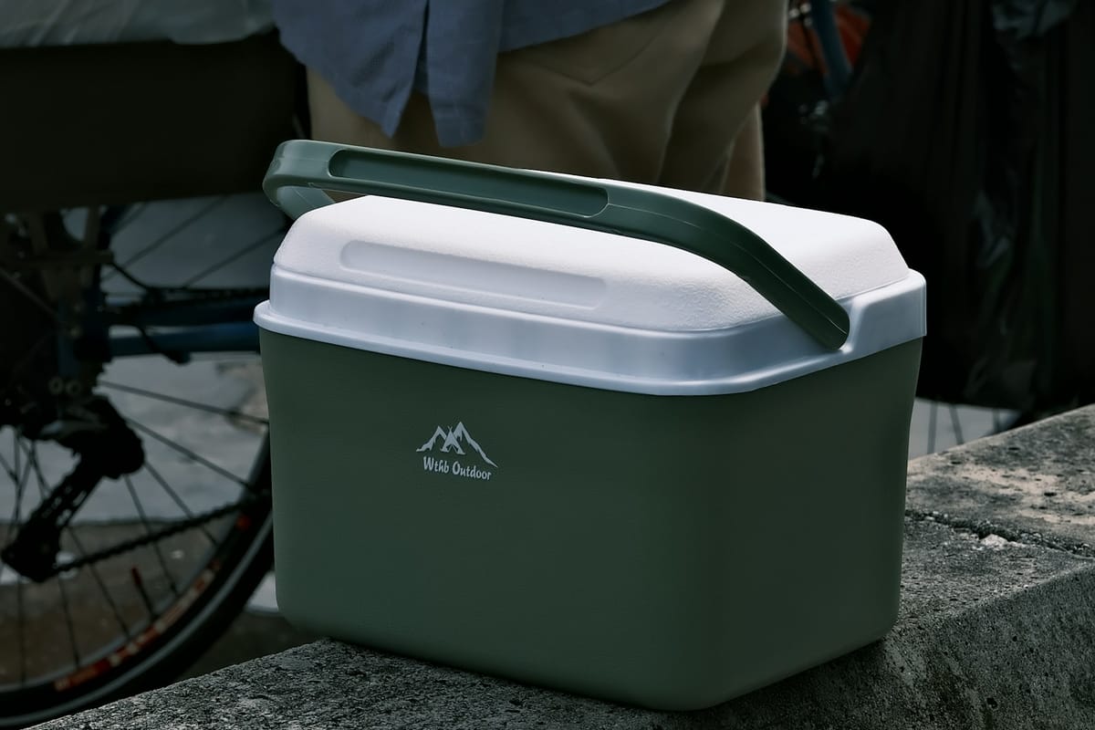 Green and white cooler box on a concrete ledge