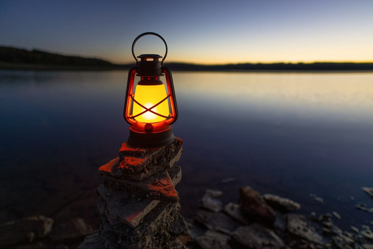 Gas lantern glowing on a rock beside the sea