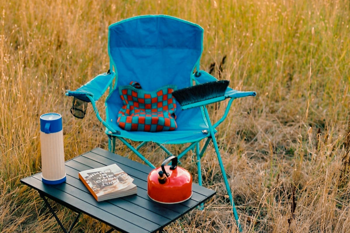 Camping chair and gear set up in tall grass