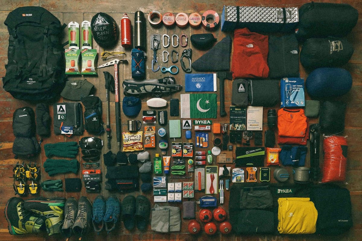Outdoor gear laid out neatly on a dark surface