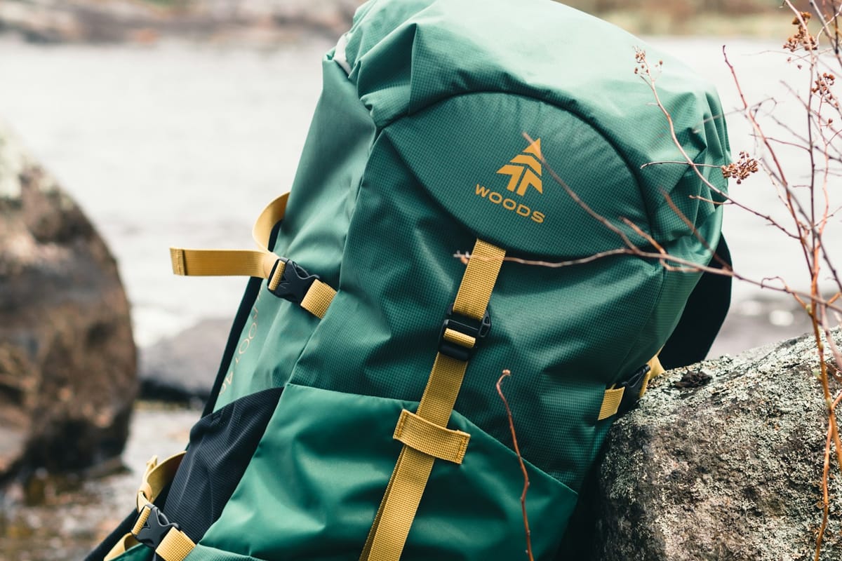 Green hiking backpack resting on a rock