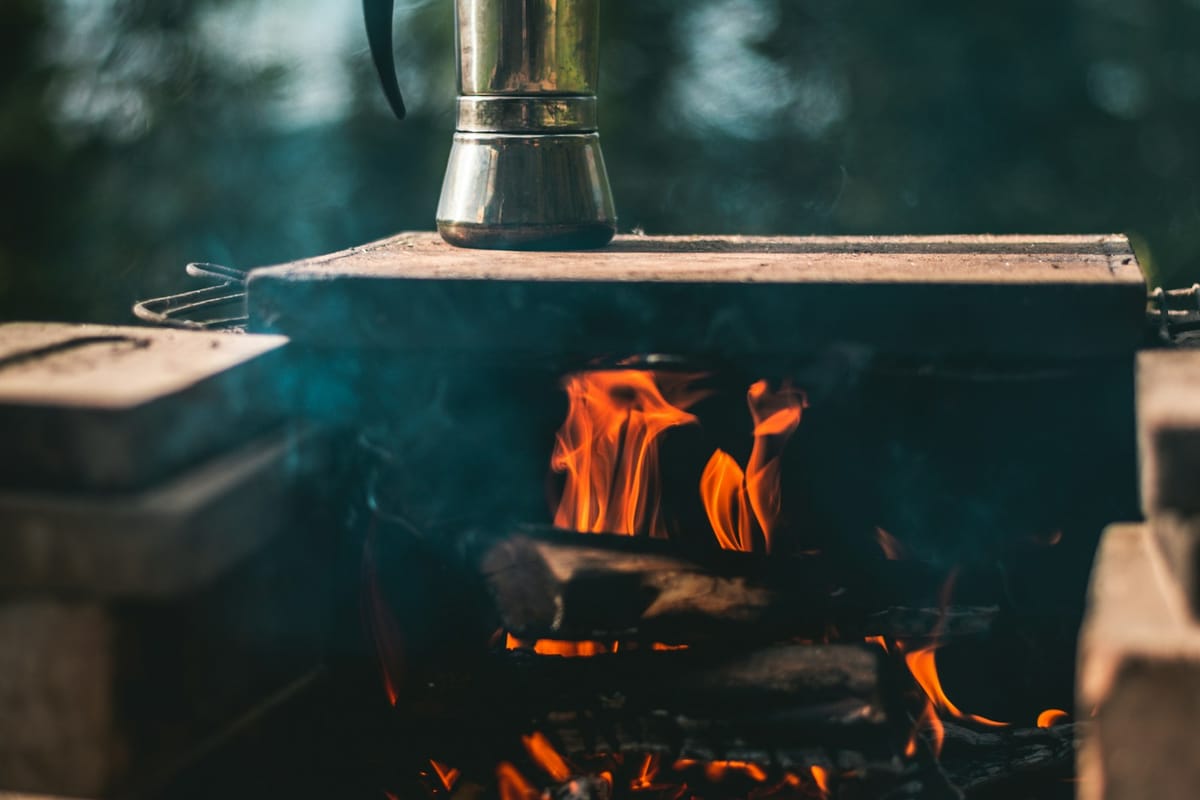 Black kettle heating over a campfire