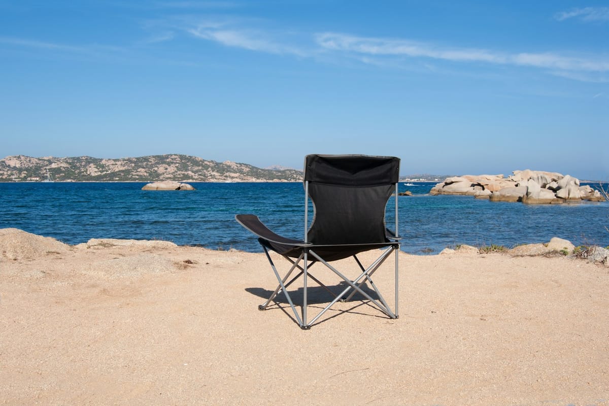 Black folding camping chair on a beach